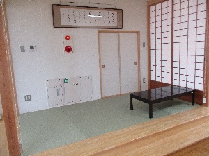 右側に障子と黒い机、手前に段差のある和室の写真