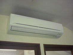 窓の上の壁に白いエアコンが設置されている写真