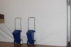 横向きに建てられた運動用マットと2台の青いラインカーの写真