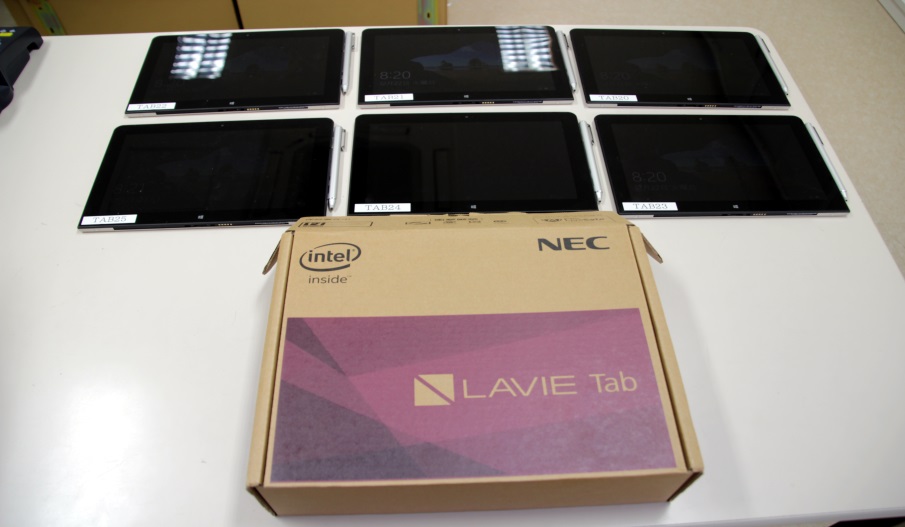 机の上に並べられた6台のNECのタブレットPCの写真