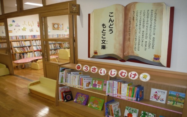 幼稚園の図書室に設置された木製の2段書架に3歳児向けの書籍が並べられている写真