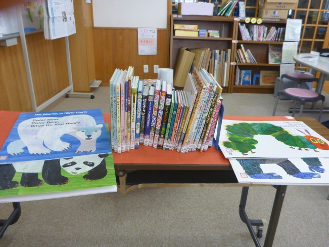 机の上に並べられた大きなサイズの絵本などの学校図書の写真