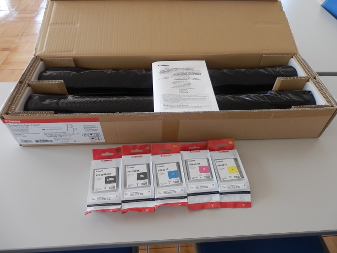 机の上に置かれた大判プリンター用のインクカートリッジなどの消耗品の写真