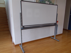 白い壁に沿わせるように設置された大型ホワイトボードの写真