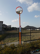 遠方からでも見やすいように設置されたカーブミラーの写真