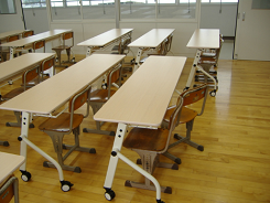 長机に椅子が置かれて整然と並んでいる写真