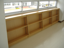 窓際に設置された上下二段の空の本棚の写真