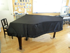 黒い布がかけられたピアノの写真