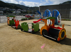 グラウンドにある電車型の遊具の写真