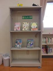 新しい本と書かれた本棚に並べられた本の写真