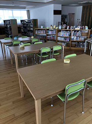 木の机と緑色の椅子が並べられた写真