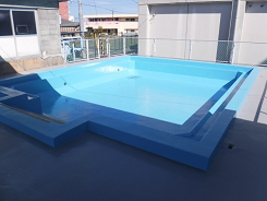 鮮やかな水色の屋外プールの写真