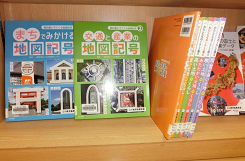 まちでみかける地図記号と書かれた本が本棚に並んでいる写真