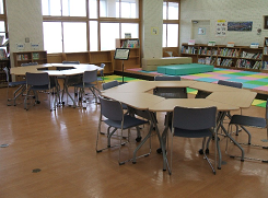 真ん中に穴が空いている机と周りに設置された椅子の写真