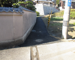 家の壁と電柱の間が舗装された写真