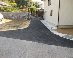 家と芝生の間が舗装された写真