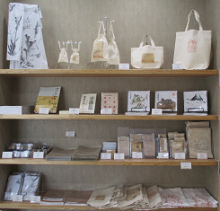 布製バッグや様々な手作り商品が並べられた棚の写真