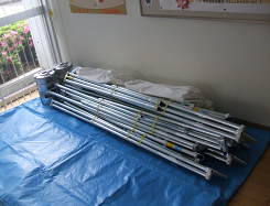 ブルーシートとまとめられた骨組みが置かれた写真