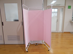ピンク色の布の3面パーテーションの写真