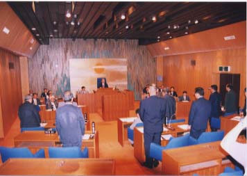 議会場の中で立っている人たちの写真