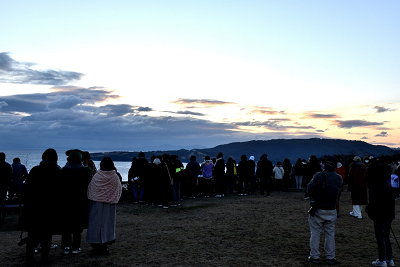 広場で大勢の人が日の出を待っている写真