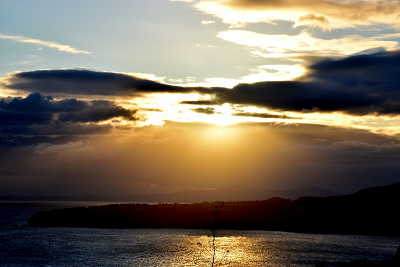 初日の出が雲の隙間から差し込んでいる写真