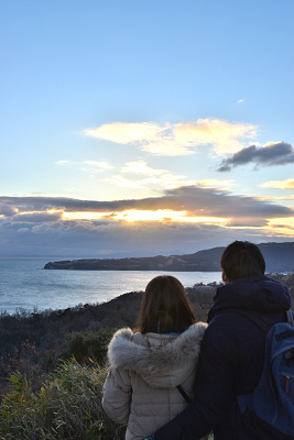 初日の出を見ている二人を後ろから撮った写真