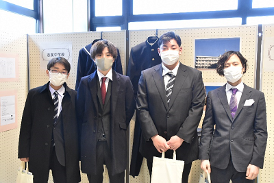 スーツ姿の男性4人が横一列に並んでいる写真