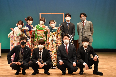 振り袖姿の女性とスーツ姿の男性が2列になって並んでいる写真