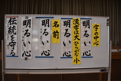ホワイトボードに貼りだされた書き初めお手本の写真