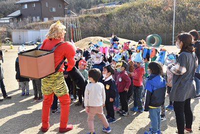 赤い鬼の仮装をした人の前に集まる園児たちの写真