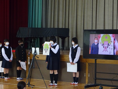 カメラの前でケヤキングと書かれた紙を掲げている児童の写真