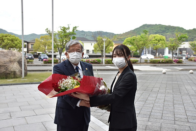女性が花束を市長に渡している写真