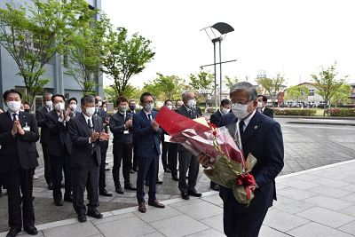 花束を持った市長が道を歩いている写真