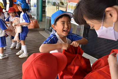 赤い着物を裂いている笑顔の園児の写真