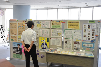 記事の展示パネルを見ている男性の後ろ姿の写真