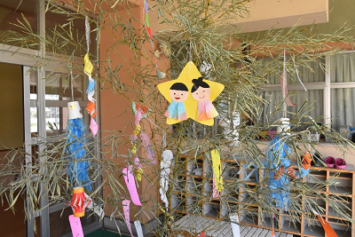 画用紙で作成された星形に和装の男女の飾りや短冊がかけられた笹の写真