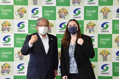 正面を向いてガッツポーズを決める男性と外国人女性が並んでいる写真