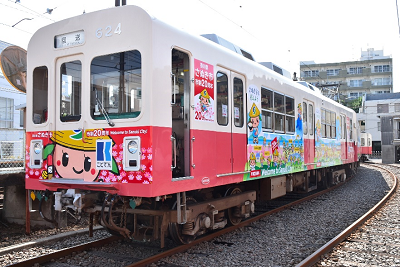 竹笠をかぶった2頭身のゆるキャラがラッピングされた電車の写真