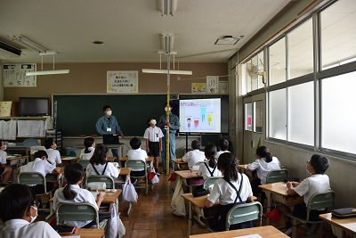 天井に届く高さの棒と児童が並んでいる写真