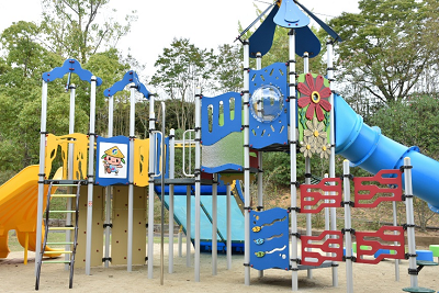 はしごや複数の滑り台が付いているアスレチック遊具の写真