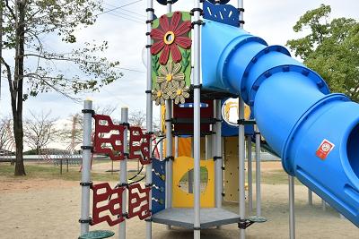 花のパネルが取り付けられたトンネル型滑り台の写真