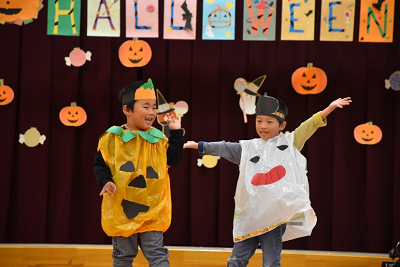 かぼちゃとお化けの仮装をした園児2名がポーズをきめている写真