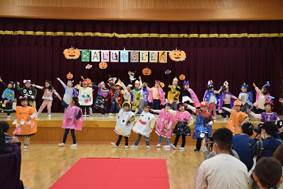 仮装をした園児たちがステージの上下に分かれてダンスを披露している写真
