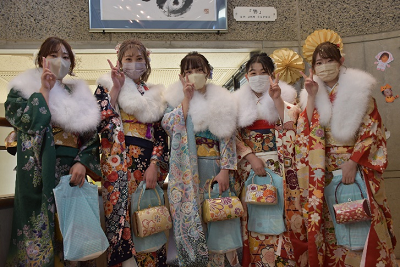 振り袖にショールを着用した女性5人がピースサインしている写真