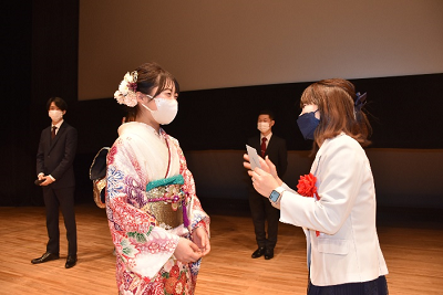 振り袖姿の女性と白いジャケットを着用した女性が話している写真