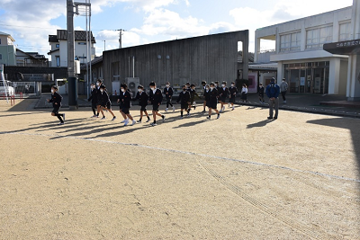 上履きのまま、校舎から校庭に避難する児童たちの写真