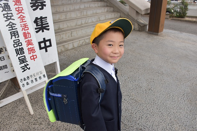 ランドセルカバーをつけたランドセルを背負っている笑顔の児童の写真