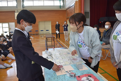 長机越しに話している児童と女性の写真