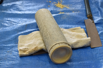 ブルーシートの上に竹と鉈が置かれている写真